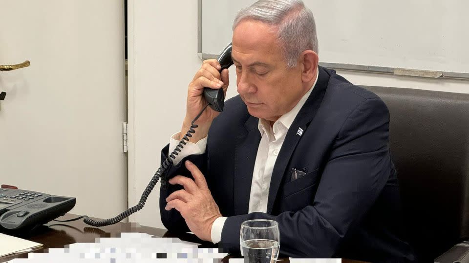 In this handout photo, released early Sunday local time, Israeli Prime Minister Benjamin Netanyahu talks on the phone with US President Joe Biden. Portions of this photo have been blurred by the source. - Israeli Prime Minister's Office