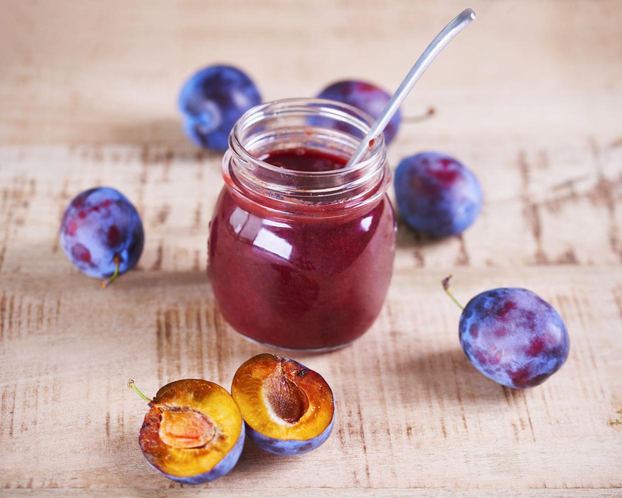 plum jam in open jar and plums