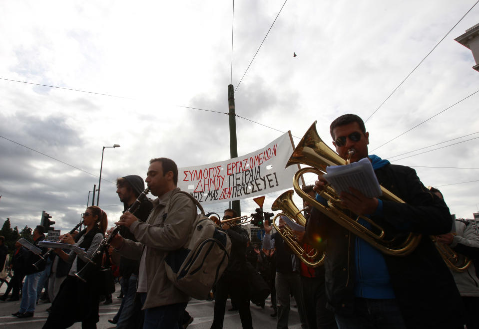 Members of Athens municipal brass band play in their instruments during a demonstration by municipal employees as the banner reads: ''Nobody to Spare'' on Tuesday, Nov. 20, 2012. About 2,000 people took part in the protest, against government plans to place 2,000 civil servants on notice ahead of reassignment or potential dismissal. Greece faces a tense wait Tuesday for vital bailout money as finance ministers from the 17 European Union countries that use the euro try to reach an agreement on how to put the country's economic recovery back on the right track. (AP Photo/Thanassis Stavrakis)