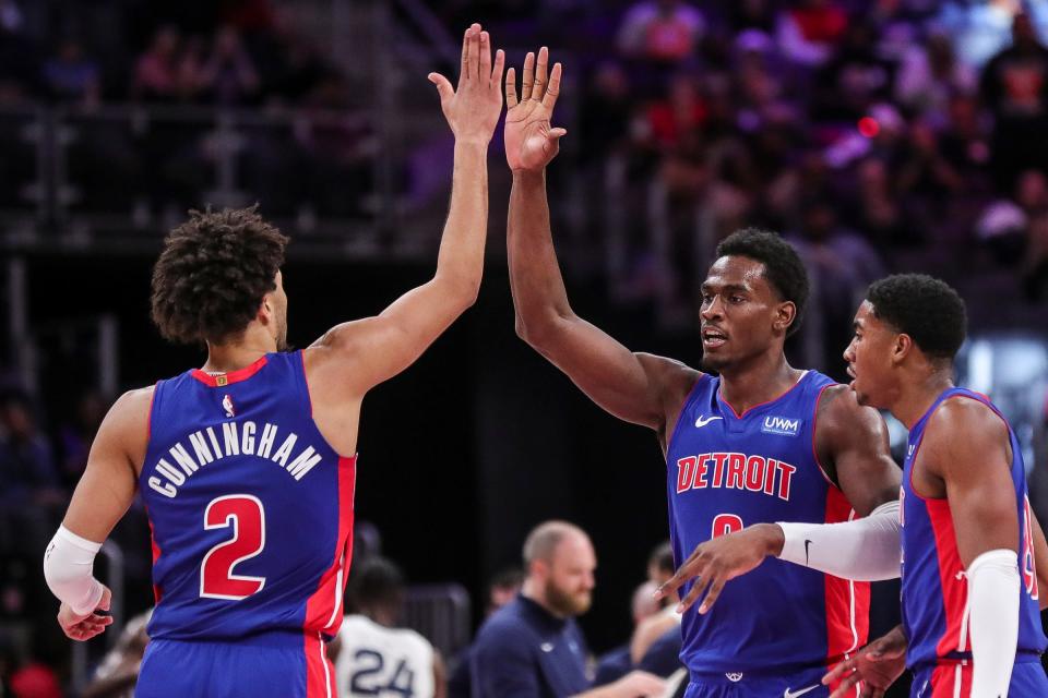 Pistons center Jalen Duren celebrates a dunk against the Grizzlies with guards Cade Cunningham and Jaden Ivey during the first half of the Pistons' 116-102 loss Wednesday, Dec. 6, 2023, at Little Caesars Arena.