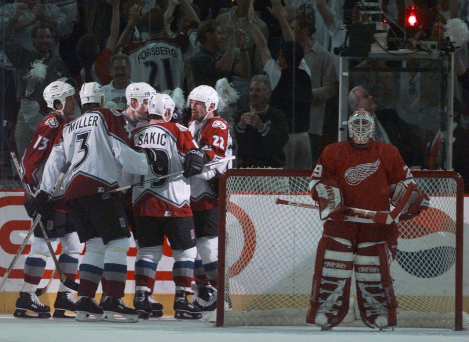 Colorado Avalanche players celebrate the second goal of the game in the first period as Detroit Red Wings goalie Mike Vernon looks down the ice in Game 5 of the Western Conference finals at McNichols Sports Arena in Denver, May 24, 1997.
