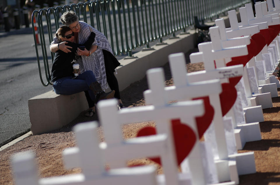 Heidi Dupin, right, embraces Jill Hale at a makeshift memorial for shooting victims, Tuesday, Oct. 1, 2019, in, Las Vegas, on the anniversary of the mass shooting two years earlier. "Something we all learned that night is no one's a stranger," said Dupin, about the people she met who helped each other during the shooting at a country music festival. "It brings out the best in you." (AP Photo/John Locher)