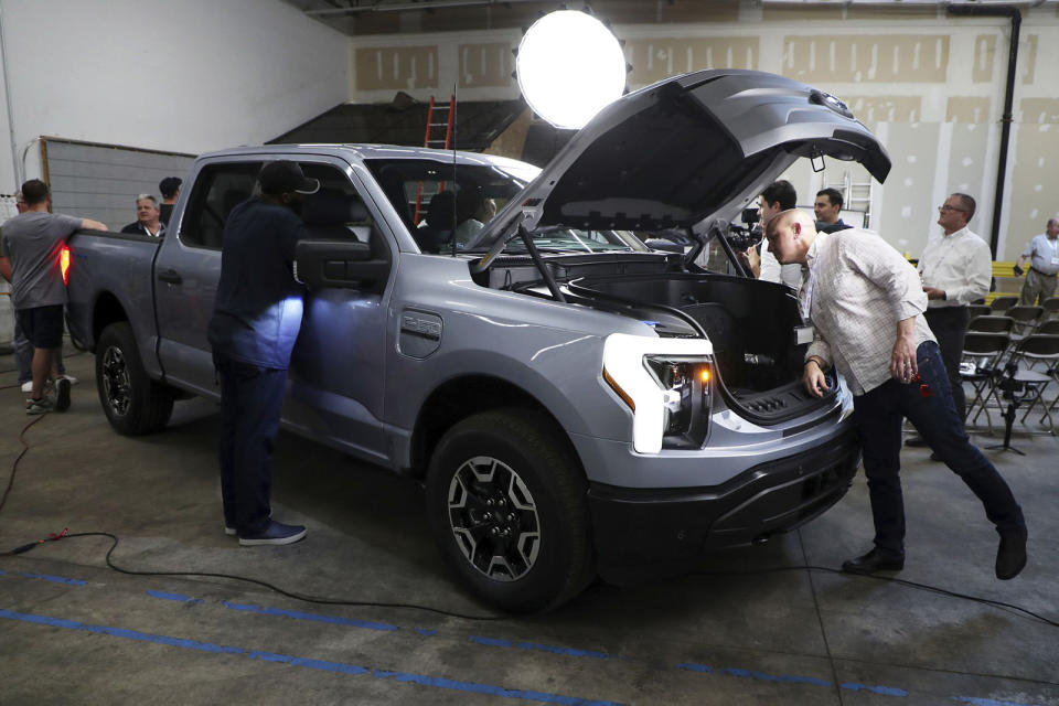 Matthew McCaffree, right, of the energy and water resource management company Itron, looks at the new Ford F-150 electric vehicle on display at Sunrun in Des Plaines on June 21, 2022. Sunrun is the largest residential solar power provider in the U.S. The Ford F-150 electric vehicle can be paired with a Sunrun bi-directional electric vehicle home charging system that enables the vehicle to power a home. (Terrence Antonio James/Chicago Tribune/Tribune News Service via Getty Images)