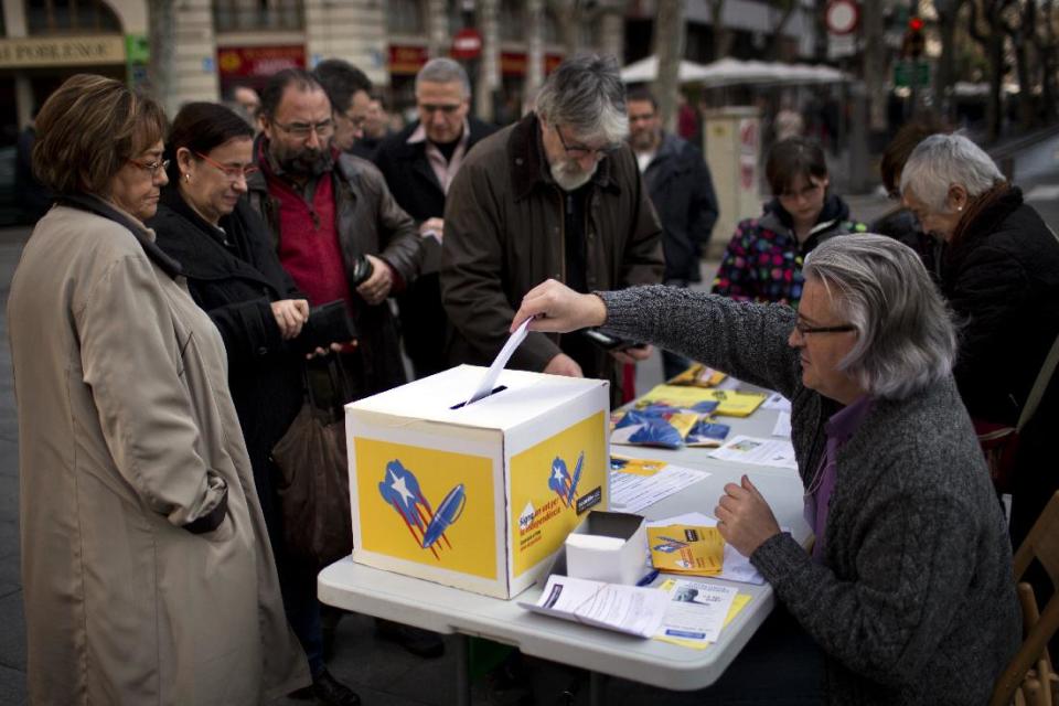 In this photo taken on Sunday, Jan. 12, 2014, a citizen from Barcelona signs a form during a campaign to encourage citizens to exercise their right of petition for the independence of Catalonia in Barcelona, Spain. After years of mass protests by Catalans demanding the right to decide whether they want to break away from Spain and form a new European nation, the wealthy northeastern region’s lawmakers vote to ask permission from Spanish authorities to hold a secession referendum in November. The request eight months ahead of a Scottish independence referendum is certain to be denied by the central government in Madrid but is virtually guaranteed of generating even more separatist fervor. (AP Photo/Emilio Morenatti)