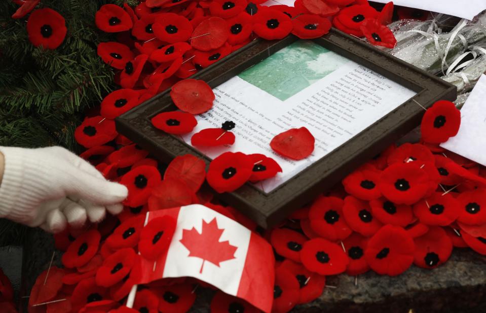 Woman places poppy on the Tomb of the Unknown Soldier following the Remembrance Day ceremony at the National War Memorial in Ottawa