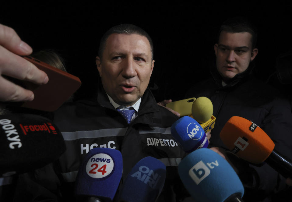 Borislav Saratov, Bulgaria's deputy chief prosecutor and head of the national investigation, speaks to media at the village of Lokorsko, near the capital Sofia, Friday, Feb. 17, 2023. An abandoned truck was found near Lokorsko, containing the bodies of 18 migrants, who appeared to have suffocated to death inside a secret compartment under a load of lumber. The Interior Ministry said that according to initial information, the truck was carrying about 40 migrants and the survivors were taken to nearby hospitals for emergency treatment. (AP Photo/ Valentina Petrova)