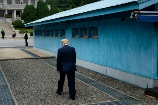 US President Donald Trump walks to the line of demarcation to meet North Korea's leader Kim Jong Un