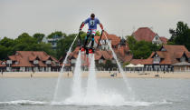 A man wearing hydro shoes flies over the water at a beach on the Baltic Sea in Sopot, Poland, on the eve of the Euro 2012 Championships.