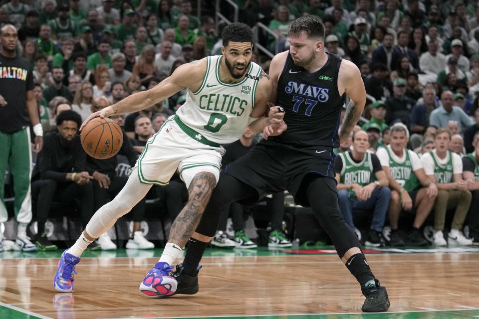 Boston Celtics forward Jayson Tatum (0) drives toward the basket as Dallas Mavericks guard Luka Doncic (77) defends during the first half of Game 1 of basketball's NBA Finals on Thursday, June 6, 2024, in Boston. (AP Photo/Charles Krupa)