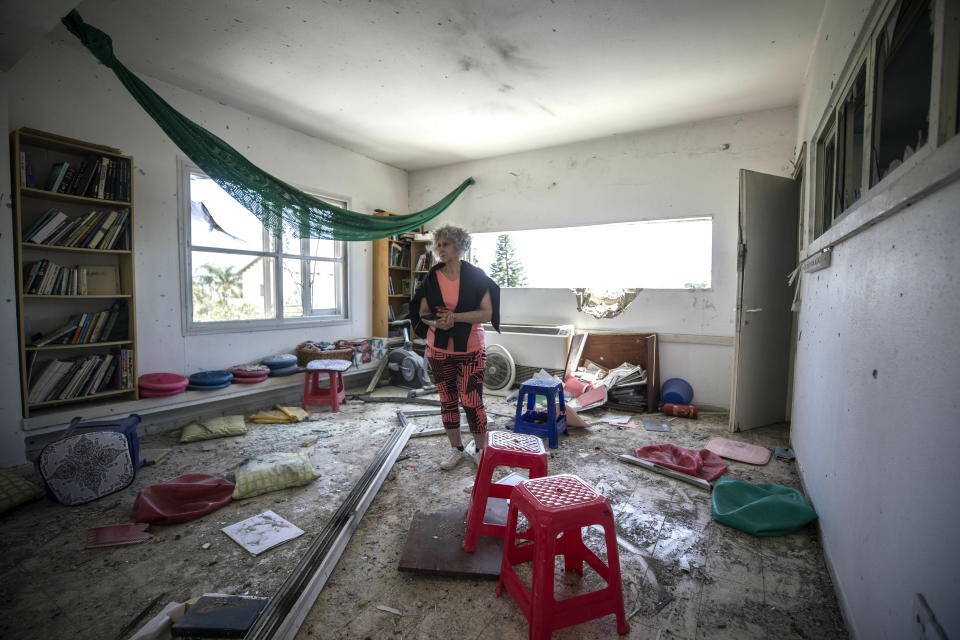 A woman looks at the damage caused by a rocket fired from Gaza that hit a house in a moshav in Israel near the border with Gaza, Saturday, May 4, 2019. Palestinian militants in the Gaza Strip fired at least 90 rockets into southern Israel on Saturday, according to the Israeli military, triggering retaliatory airstrikes and tank fire against militant targets in the blockaded enclave and shattering a month-long lull in violence. (AP Photo/Tsafrir Abayov)