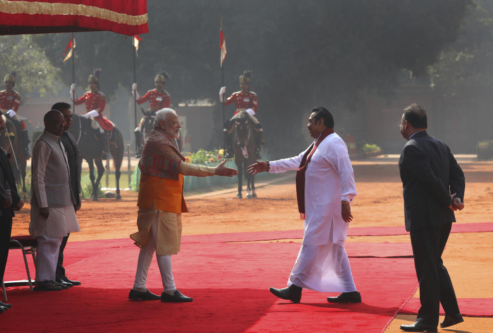 FILE - Indian Prime Minister Narender Modi, center left, greets his then Sri Lankan counterpart Mahinda Rajapaksa, during a ceremonial reception at the Indian presidential palace, in New Delhi, India, Saturday, Feb. 8, 2020. Sri Lanka's strategic location has attracted outsized interest in the small island nation from regional giants China and India for more than a decade, with Beijing and its free-flowing loans and infrastructure investments widely seen as having gained the upper hand in the quest for influence. (AP Photo/Manish Swarup, File)