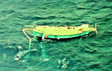 The capsized yacht Thuriya of solo sailor Abhilash Tomy is pictured at sea in this September 24, 2018 handout photo by the Indian Navy. Indian Navy/Handout via REUTERS