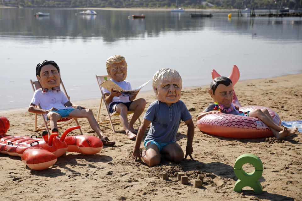 Oxfam activists, wearing masks of the G-7 leaders, enact a performance at the beach in Hendaye, France, Saturday, Aug. 24, 2019. World leaders and protesters are converging on the southern French resort town of Biarritz for the G-7 summit. The masks resemble, from left, Canadian Prime Minister Justin Trudeau, US President Donald Trump, Britain's Prime Minister Boris Johnson and French President Emmanuel Macron. (AP Photo/Emilio Morenatti)