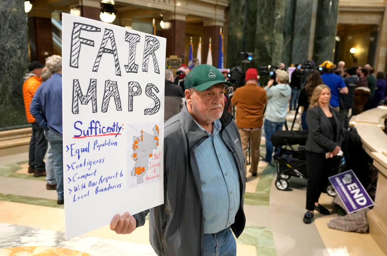 Brad Munger of Janesville holds a sign as the Wisconsin Supreme Court hears arguments in a case challenging the state's electoral maps on Nov. 21.