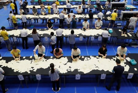 Election officers count votes at a ballot counting centre for Japan's upper house election in Tokyo