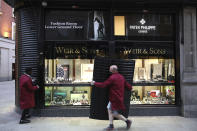 People place shutters on a jewellery shop in Dublin, Ireland, Wednesday, Oct. 21, 2020. With COVID-19 cases on the rise, the government has imposed a tough new lockdown, shutting down non-essential shops, limiting restaurants to takeout service and ordering people to stay within five kilometers (three miles) of their homes for the next six weeks. (AP Photo/Peter Morrison)