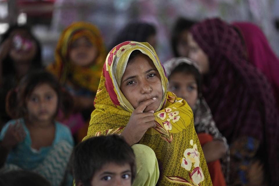 Girls attend a school set up in a tent in Arzi Naich village in Dada, a district of Pakistan's Sindh province, Wednesday, May 17, 2023. Many children are still without schools as authorities struggle to repair the extensive damage. (AP Photo/Anjum Naveed)