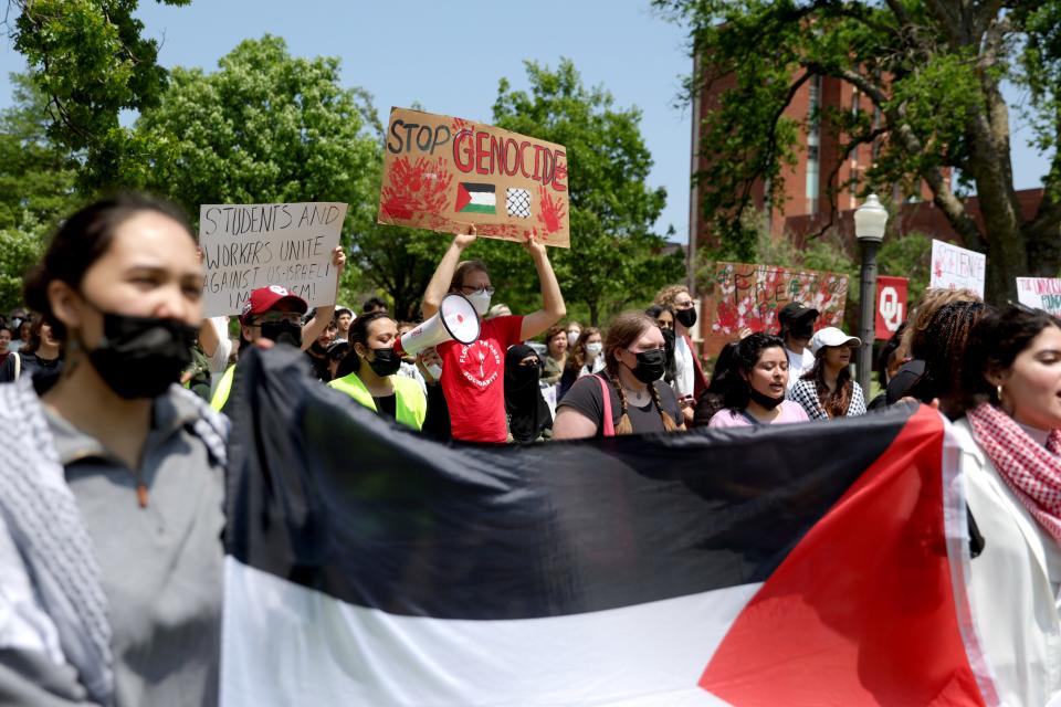 People hold signs in support of Palestine during a May Day rally hosted Wednesday by the University of Oklahoma's Student Coalition for Palestinian Liberation and Student Socialist League on the OU campus in Norman.