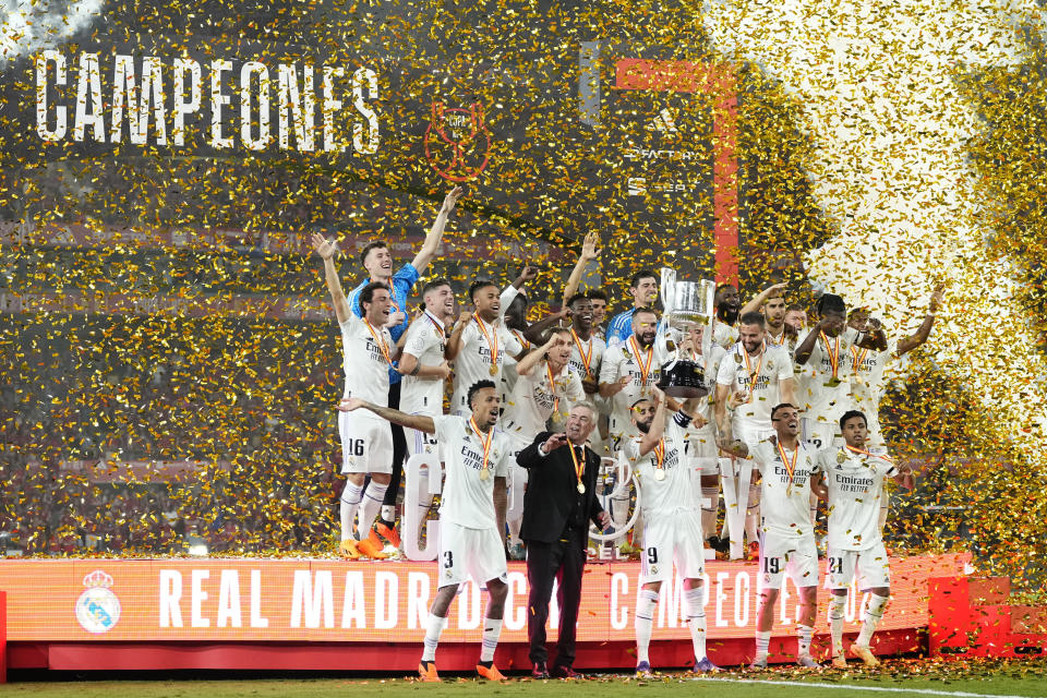 Real Madrid team players and head coach Carlo Ancelotti celebrate with the trophy after Madrid defeated Osasuna 2-1 in the Copa del Rey soccer final at La Cartuja stadium in Seville, Spain, Saturday, May 6, 2023. (AP Photo/Jose Breton)