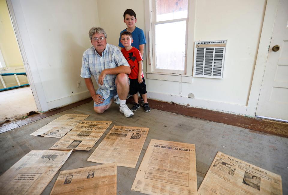 Joe Gideon with his grandsons Grady Gideon (in back) and Creek Clinkenbeard and several of the 1943 editions of the Sunday News and Leader copies Gideon discovered under the carpet of a 112-year-old Forsyth home he and his wife recently purchased and started rehabbing. 