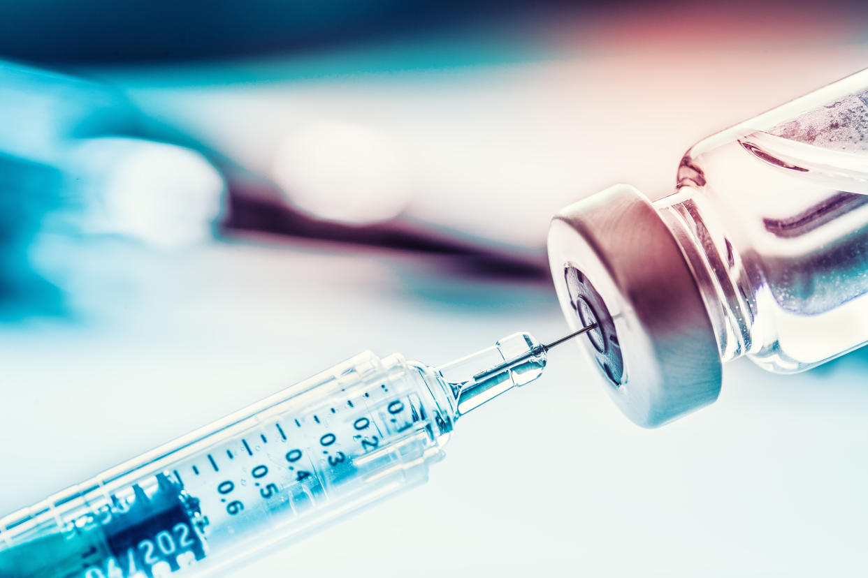 A close-up of a medical syringe in a vial.