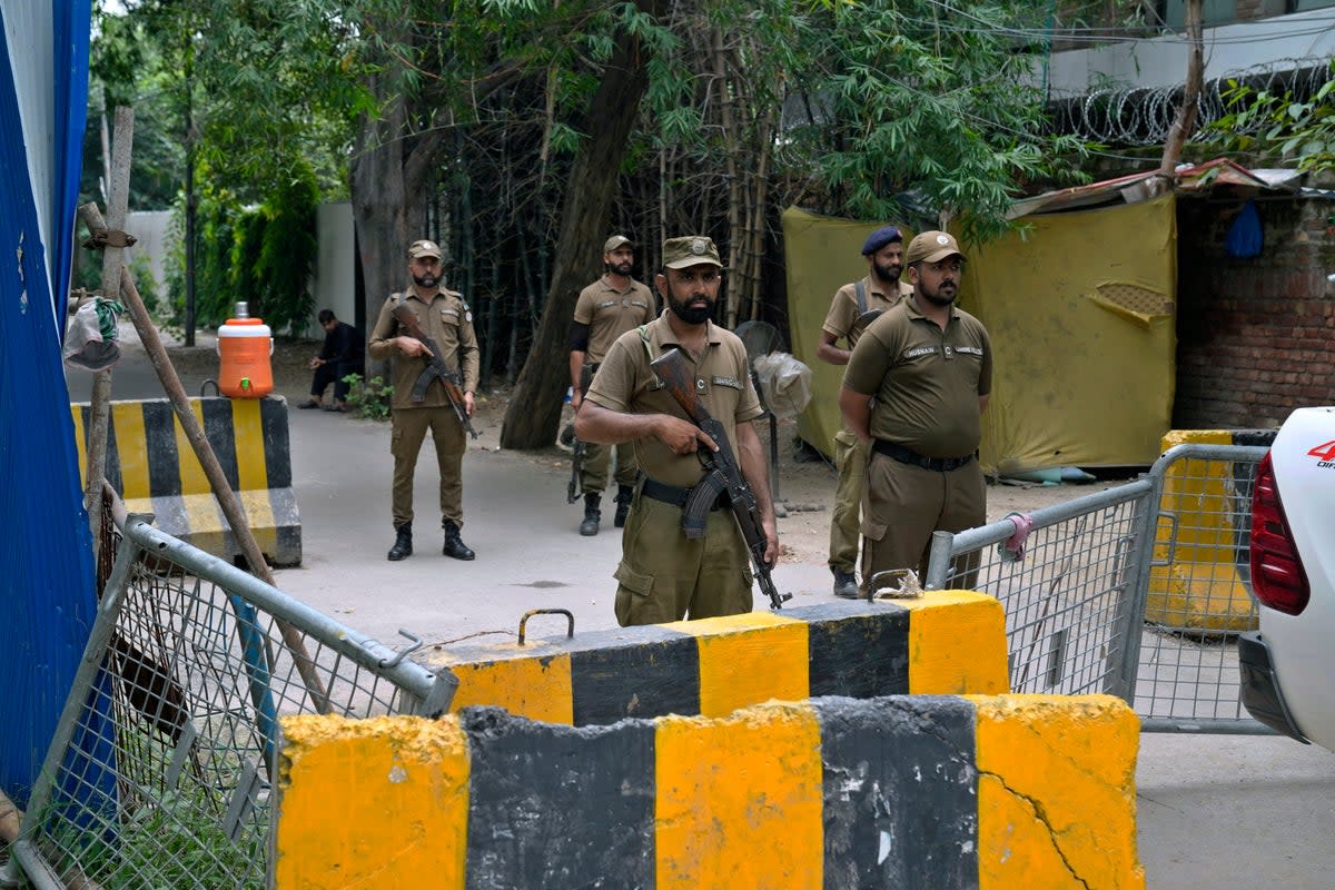 Police officers stand guard outside the residence of Pakistan's former prime minister Mr Khan on Saturday (AP)