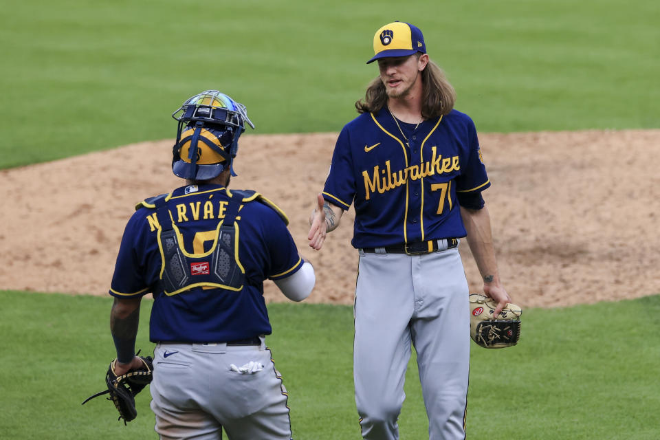 Milwaukee Brewers' Omar Narvaez, left, reacts with Josh Hader (71) after the final out of a baseball game against the Cincinnati Reds in Cincinnati, Saturday, May 22, 2021. The Brewers won 4-3. (AP Photo/Aaron Doster)