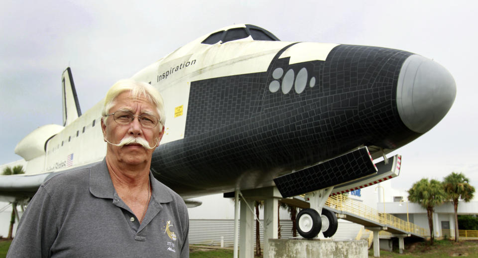 In this Wednesday, July 11, 2012 photo, former space shuttle worker Terry White poses in front of a mock space shuttle at the Astronaut Hall of Fame in Titusville, Fla. White was a project manager who worked 33 years for the shuttle program until he was laid off after Atlantis landed last July 21. (AP Photo/John Raoux)