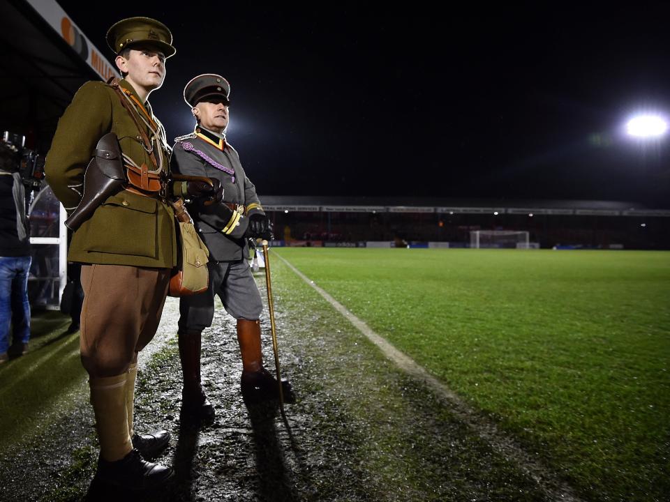 People in military WWI uniforms watch the "Game of Truce", a recreation of a First World War Christmas truce football match, in Aldershot, west of London, on December 17, 2014.