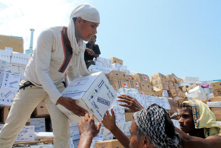 Yemeni workers unload medical aid boxes from a boat carrying 460 tonnes of Emirati relief aid that docked in the port of the city of Aden, on May 24, 2015