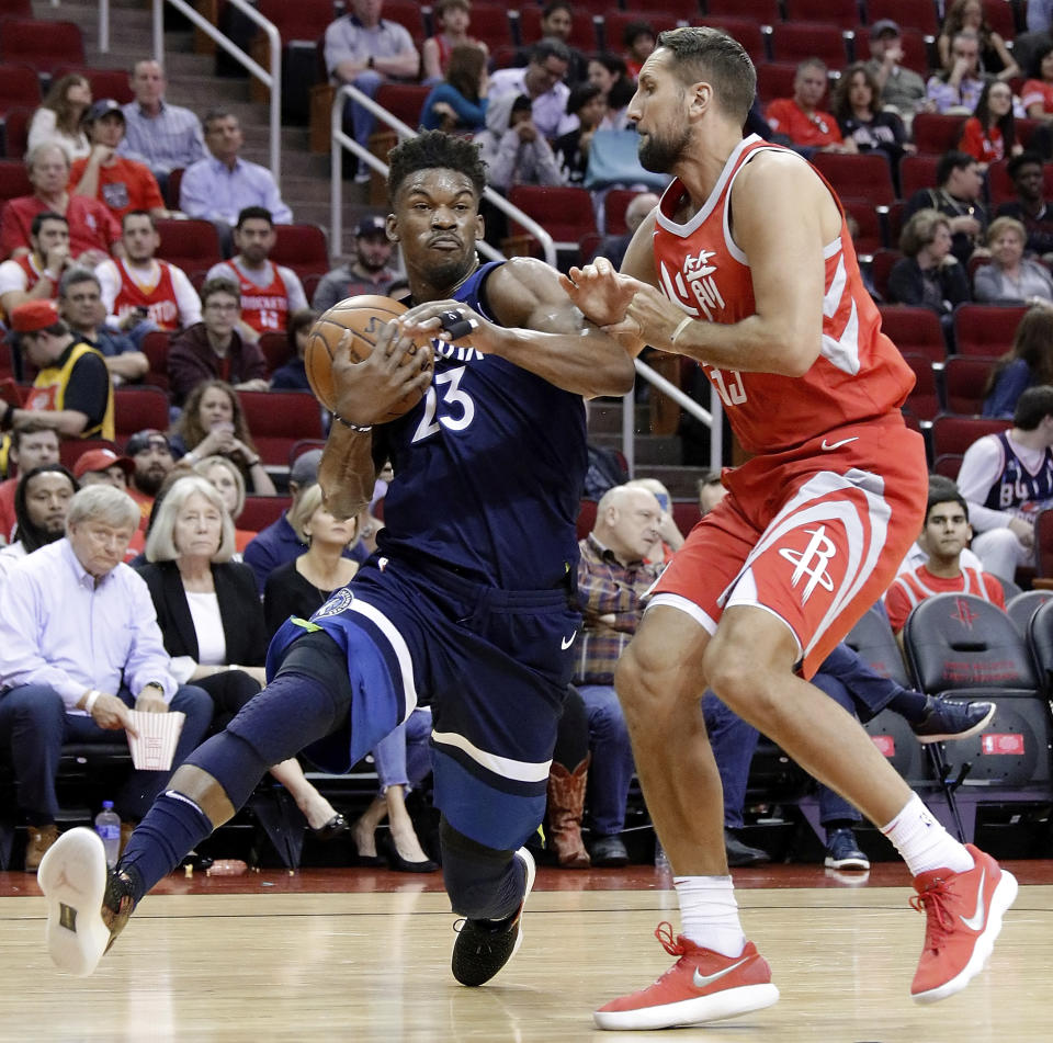 Minnesota Timberwolves guard Jimmy Butler (23) drives around Houston Rockets forward Ryan Anderson (33) during the first half of an NBA basketball game Friday, Feb. 23, 2018, in Houston. (AP Photo/Michael Wyke)