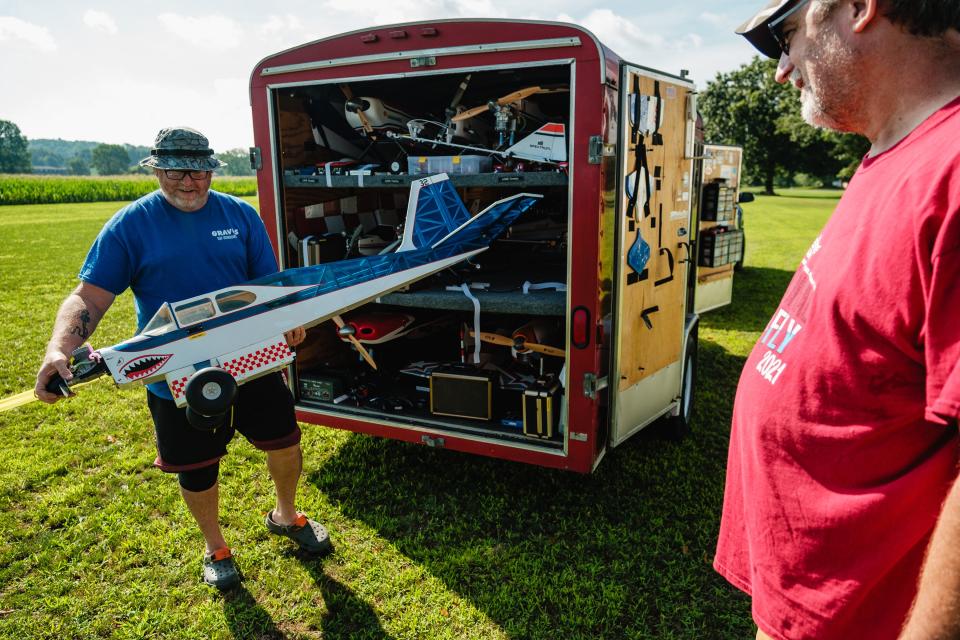 Timothy Lohr, left, of Sherrodsville prepares one of his 14 aircraft brought in for the annual Academy of Model Aeronautics National Model Aviation Day hosted by the OldTown Valley Flyer's Club, Saturday, Aug. 12 on a private field in Lawrence Township.