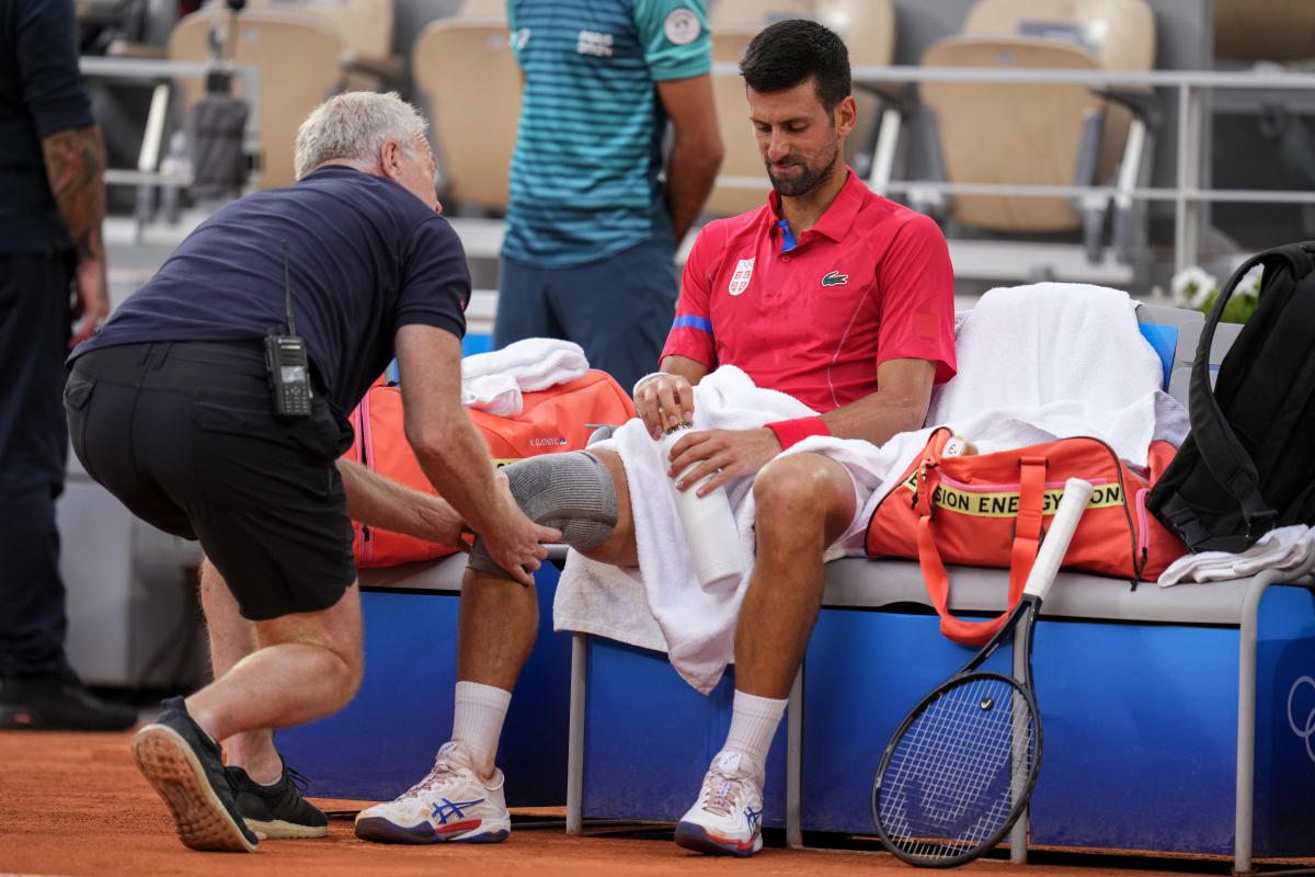 Novak Djokovic’s knee injury bothers him at the Paris Olympics but he beats Stefanos Tsitsipas