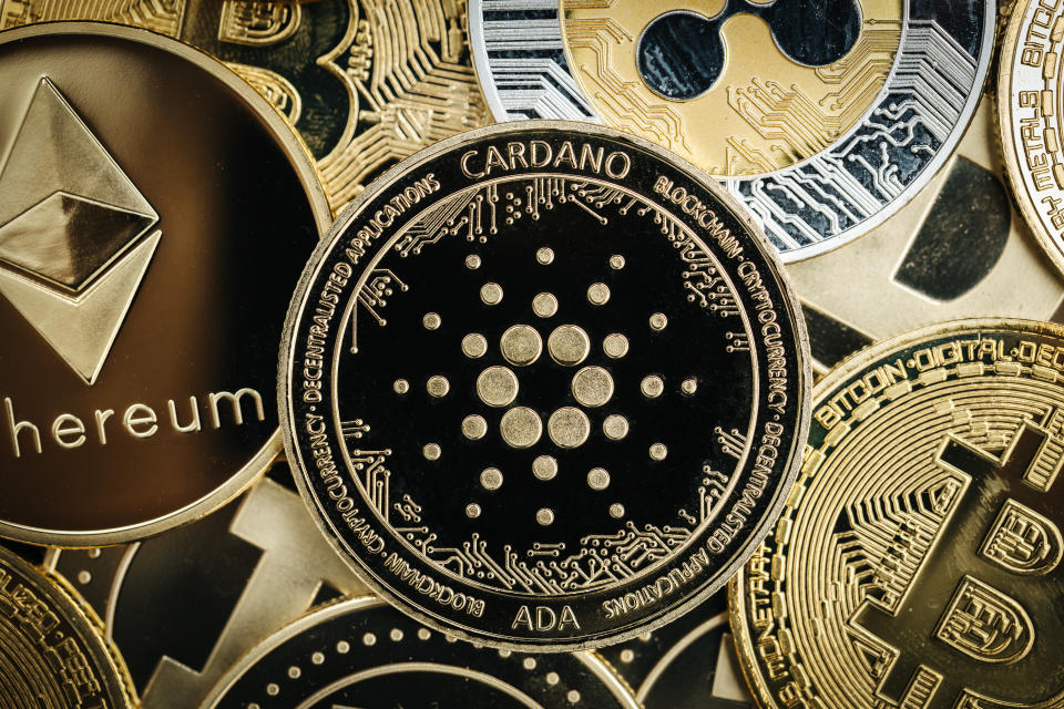 Physical Cardano cryptocurrency coin close-up, on top of other cryptocurrency coins