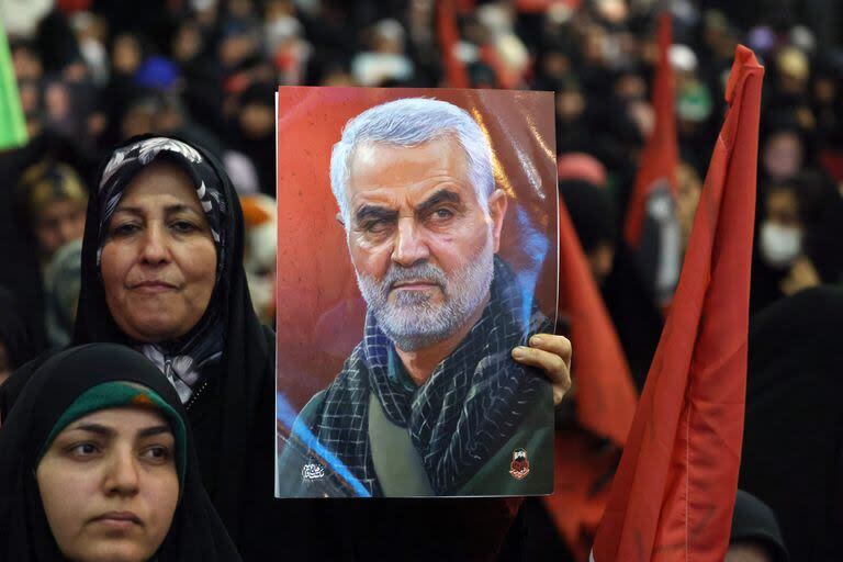 Una mujer iraní sostiene un retrato del fallecido comandante iraní de alto rango Qasem Soleimani durante la ceremonia conmemorativa que marca el aniversario de su asesinato en la capital iraní, Teherán, el 3 de enero de 2024.