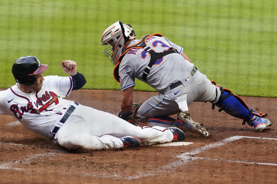 Atlanta Braves' Freddie Freeman beats the tag from New York Mets catcher James McCann (33) to score during the first inning of a baseball game Wednesday, June 30, 2021, in Atlanta. (AP Photo/John Bazemore)