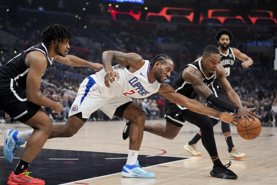 Los Angeles Clippers forward Kawhi Leonard vies for a loose ball against Brooklyn Nets guard Lonnie Walker IV during the first half of an NBA basketball game, Sunday, Jan. 21, 2024, in Los Angeles. (AP Photo/Marcio Jose Sanchez)