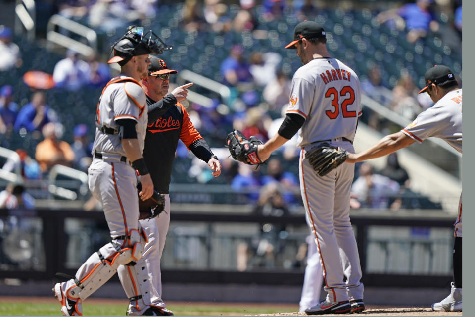 Baltimore Orioles manager Brandon Hyde points to the bullpen as he comes to take Orioles starting pitcher Matt Harvey (32) from the mound during the fifth inning of a baseball game against the New York Mets, Wednesday, May 12, 2021, in New York. (AP Photo/Kathy Willens)