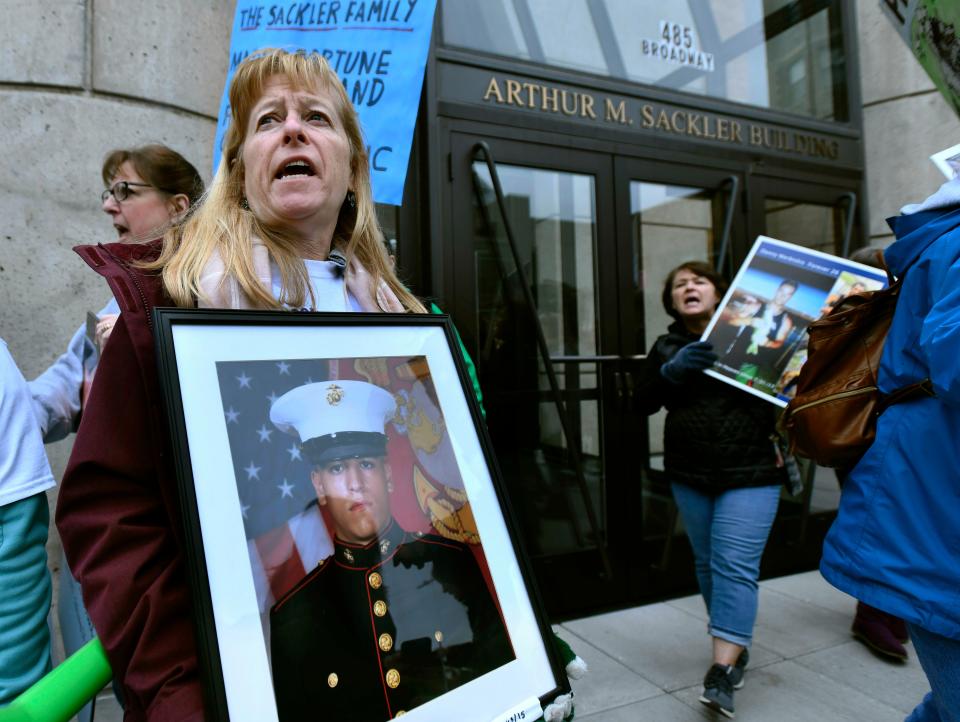 Kathleen Scarpone, of Kingston, N.H., protests in front of the Arthur M. Sackler Museum at Harvard University, Friday, April 12, 2019, in Cambridge, Mass. Scarpone, who's son Sgt. Joseph Scarpone, a native of Methuen, Mass., died in 2015, took part in a demonstration by parents who have lost a child to opioid abuse, campaigning for the removal of the Sackler family name from the building at Harvard. (AP Photo/Josh Reynolds)