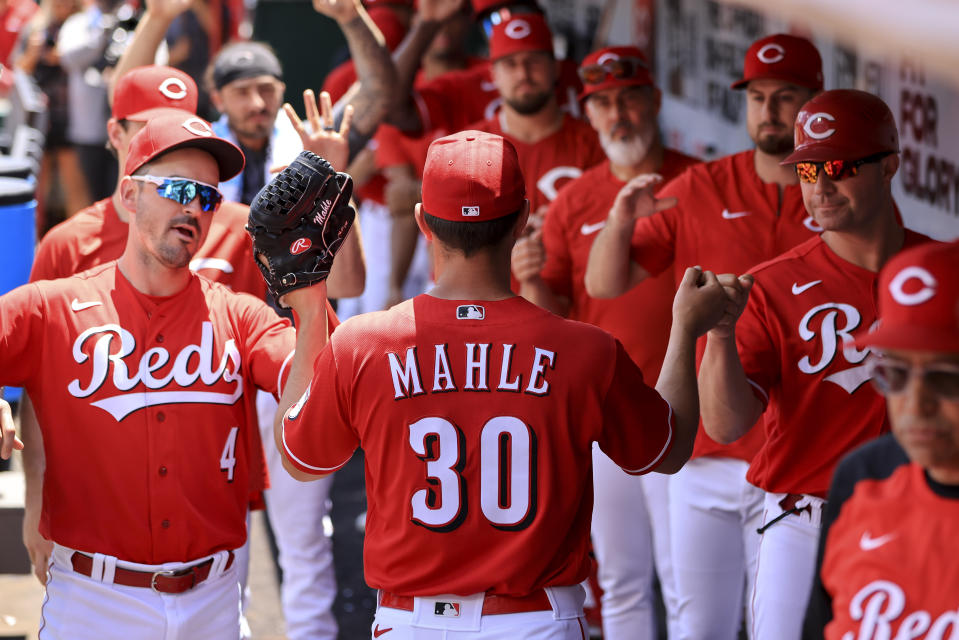 Cincinnati Reds' Tyler Mahle (30) high-fives teammates in the dugout after being pulled during the seventh inning of a baseball game against the San Francisco Giants in Cincinnati, Sunday, May 29, 2022. (AP Photo/Aaron Doster)