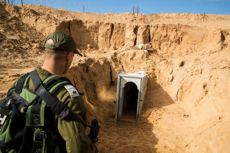 An Israeli soldier stands next to an entrance to what the Israeli military say is a cross-border attack tunnel dug from Gaza to Israel, on the Israeli side of the Gaza Strip border near Kissufim, Israel January 18, 2018. REUTERS/Jack Guez/Pool