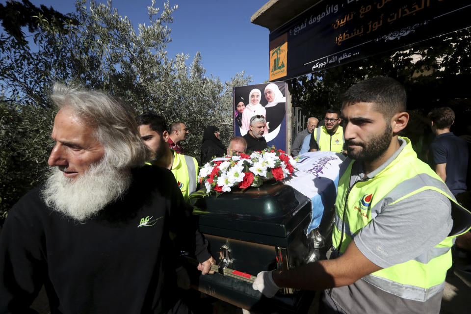 Relatives of the victims who were killed by an Israeli airstrike, hold one of the coffin during their funeral procession in the town of Ainata, a Lebanese border village with Israel in south Lebanon, Tuesday, Nov. 7, 2023. A Lebanese woman and her three grand daughters were laid to rest in their hometown in southern Lebanon two days after they were killed in an Israeli drone strike while in a car near the Lebanon-Israel border. (AP Photo/Mohammed Zaatari)