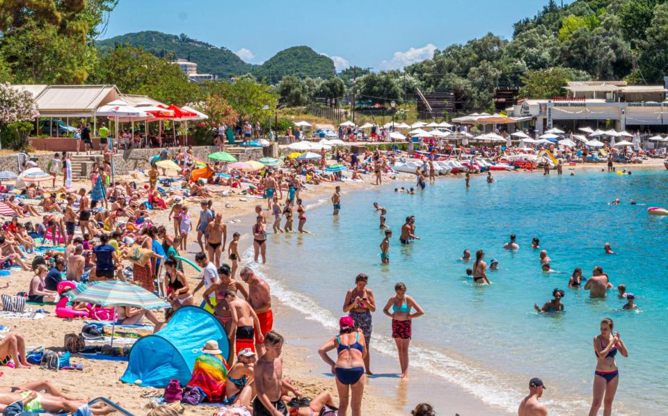 Tourists brave the sun on a beach in Palaiokastritsa, Corfu