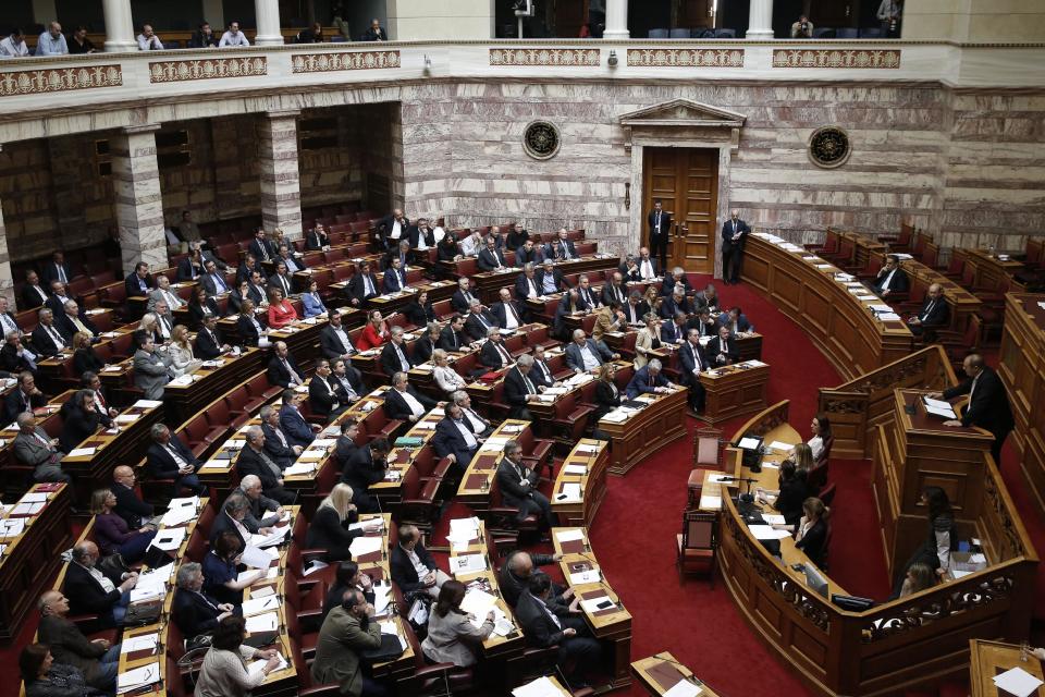 Golden Dawn lawmaker Georgios Germenis, right, one of five party lawmakers jailed pending trial for allegedly running a criminal organization, speaks during a parliament session in Athens, on Wednesday May 7, 2014. Two jailed Greek lawmakers granted special prison leave have appeared in Parliament to defend themselves against charges linked with a judicial crackdown on the Nazi-inspired Golden Dawn party. (AP Photo/Petros Giannakouris)