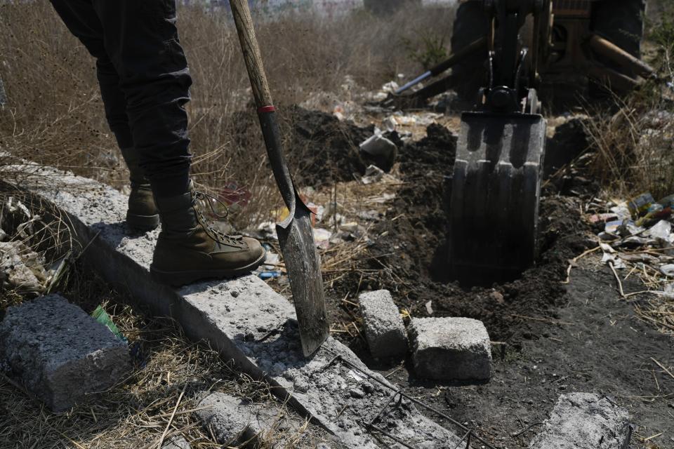 A relative stands by as a mechanical shovel removes earth from a clandestine grave during a search for missing loved ones, in Tepotzotlán, Mexico, Friday, April 19, 2024. Hundreds of collectives searching for missing loved ones fanned out across Mexico on Friday as part of a coordinated effort to raise the profile of efforts that are led by the families of the tens of thousands of missing across Mexico without support from the government. (AP Photo/Marco Ugarte)