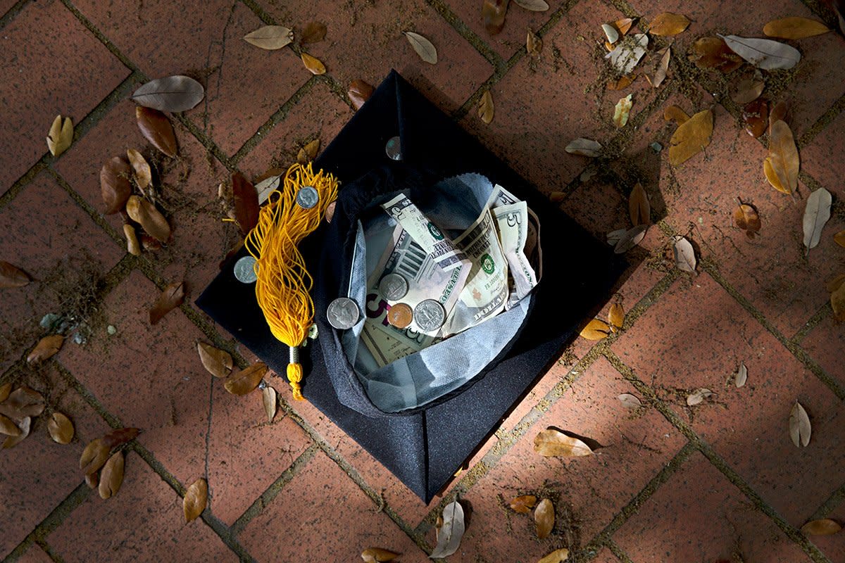 graduation cap filled with money on sidewalk: not the best way to save money for kids