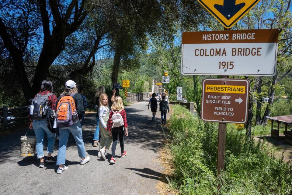 Tourists walk toward the Coloma Bridge at the south fork of the American River in April on property once owned by Rufus Burgess in Coloma.