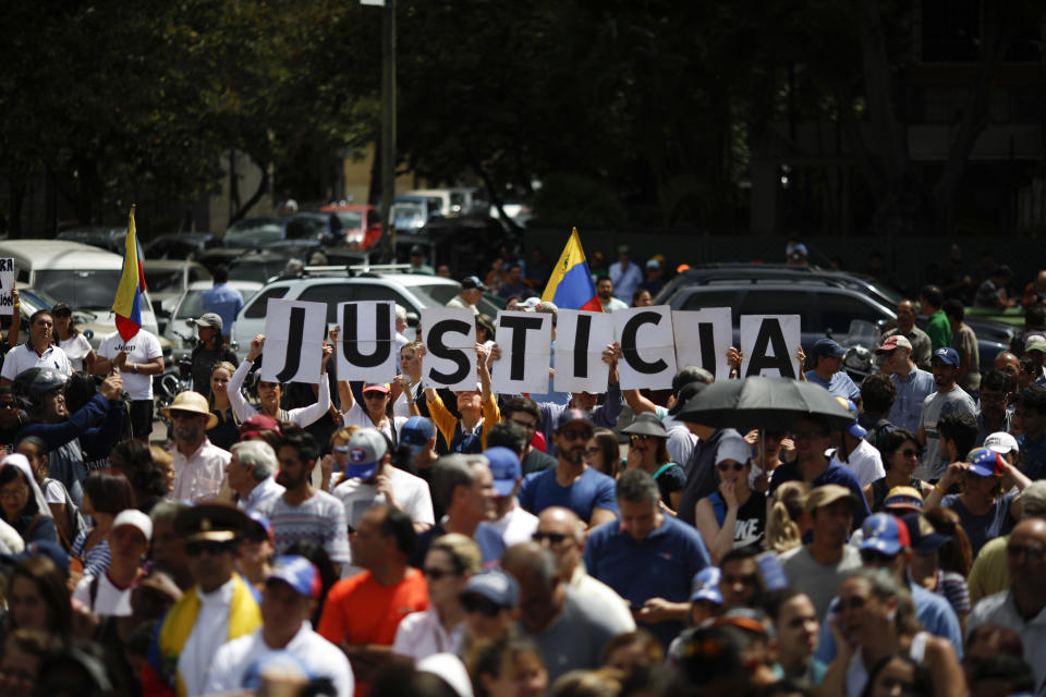 Demonstrators hold banner that reads “Justice” during a rally of the opposition with the self-proclaimed interim president Guaido in Caracas, January 25, 2018. Marco Bello. Image: Getty