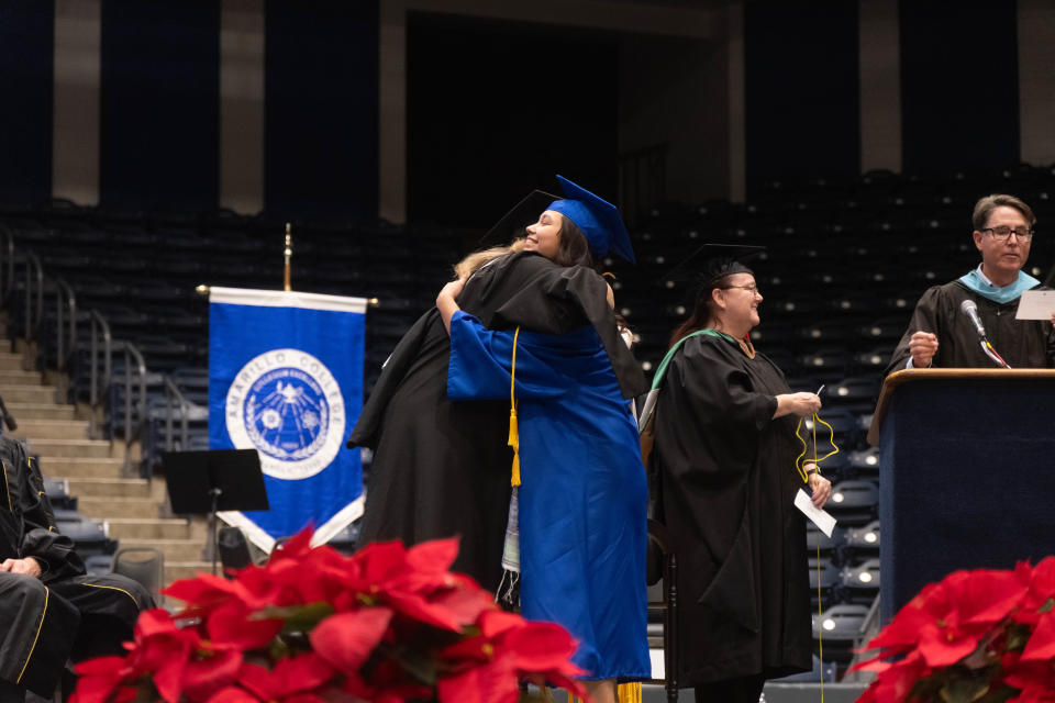 Leah Aviles receives a hug as she is awarded her diploma with honors Friday evening at the Amarillo College Commencement Ceremony at the Amarillo Civic Center.