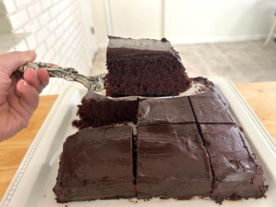 A piece being lifted out of a chocolate cake with mocha frosting